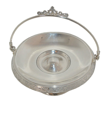 Vintage silver-plated candy dish early 1900's with handle and on pastel.