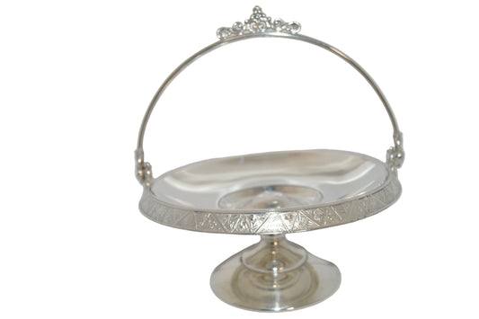 Vintage silver-plated candy dish early 1900's with handle and on pastel.